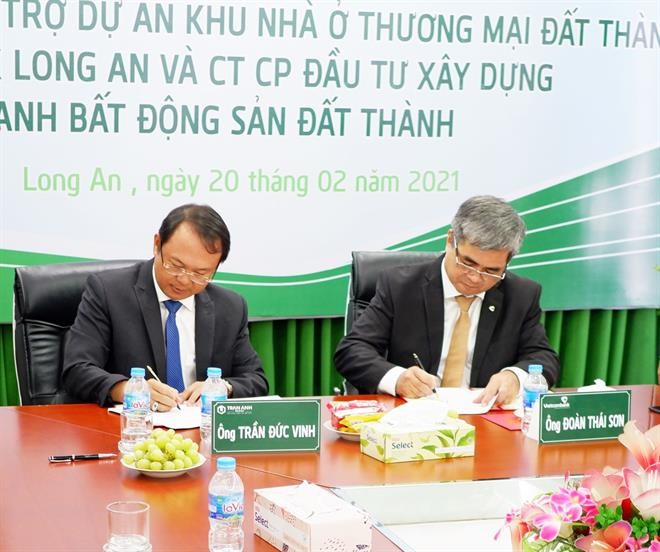  Ông Trần Đức Vinh – Chủ tịch HĐQT Công ty CP ĐT XD và KD BĐS Đất Thành (bên trái) và ông Đoàn Thái Sơn - Giám đốc Vietcombank Long An (bên phải) ký kết hợp đồng tín dụng